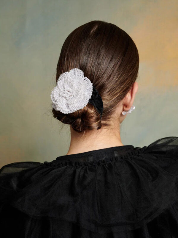 Multi-way accessory. An adjustable velvet ribbon tie with a pearl flower trim.